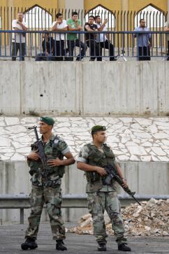 Hezbollah supporters look on as Lebanese army soldiers clear roadblocks along the highway leading to Beirut's airport. (Patrick Baz | AFP)