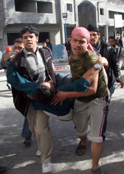 Palestinians in Gaza City carry a victim of the Israeli assault to Al Shifa hospital (Thair al-Hassany | propaimages)