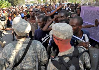 U.S. soldiers hold back a large gathering of displaced people waiting for aid in Port-au-Prince (Master Sgt. Jeremy Lock)