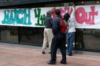 Activists post a banner for the March 4 Day of Action at Laney College in Oakland (TheBlackHour.com)
