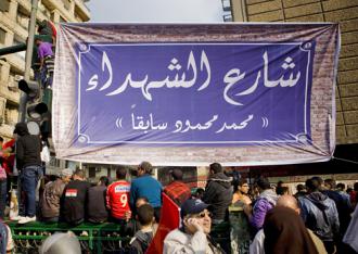 Protesters hang a banner at the entrance to Mohammad Mahmoud Street renaming it "Martyrs Street" (Hossam el-Hamalawy)