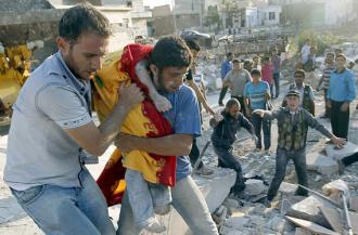 Aleppo residents carry a wounded child away from the site of government bombing (Goran Tomasevic)