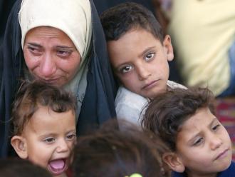 An Iraqi woman and her children in the district of Hor Rejab in southwestern Baghdad (Ahmad Al-Rubaye | AFP)
