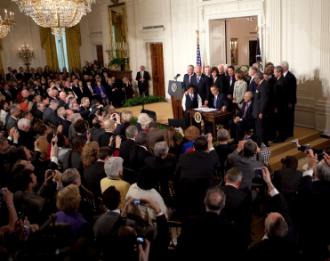 Barack Obama signs health care legislation in front of Democratic lawmakers in the East Room of the White House (Lawrence Jackson)