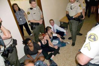 Four of the Equality 9 block a doorway during their 2010 sit-in (Mark Gabrish Conlan | Indybay.org)