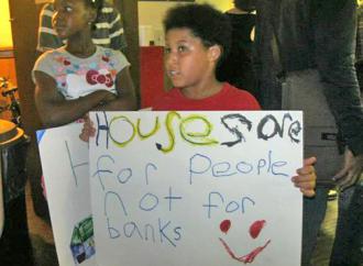 Children join in with hand-made signs at a Chicago town hall meeting (Megan Selby)