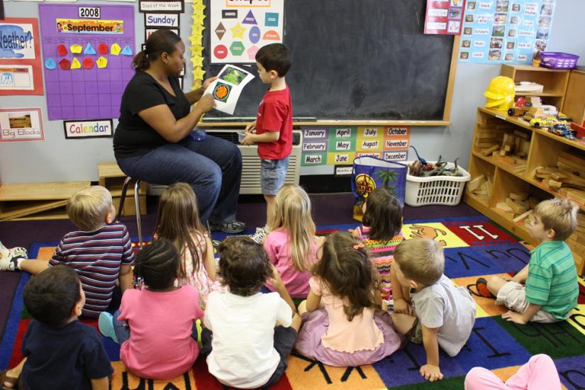 A kindergarten teacher leads a discussion with her students