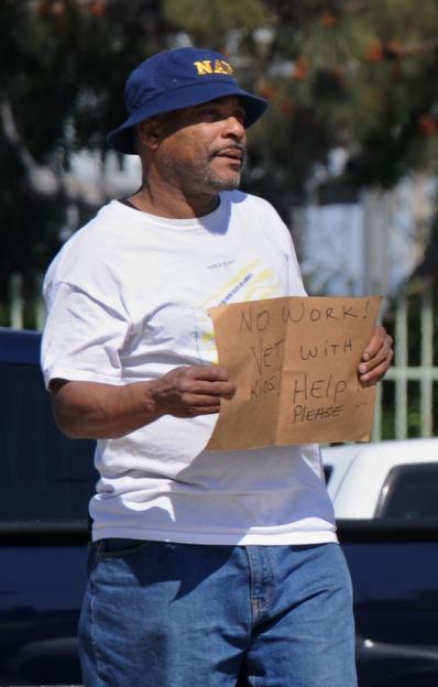 An unemployed veteran asks for money from motorists in Los Angeles
