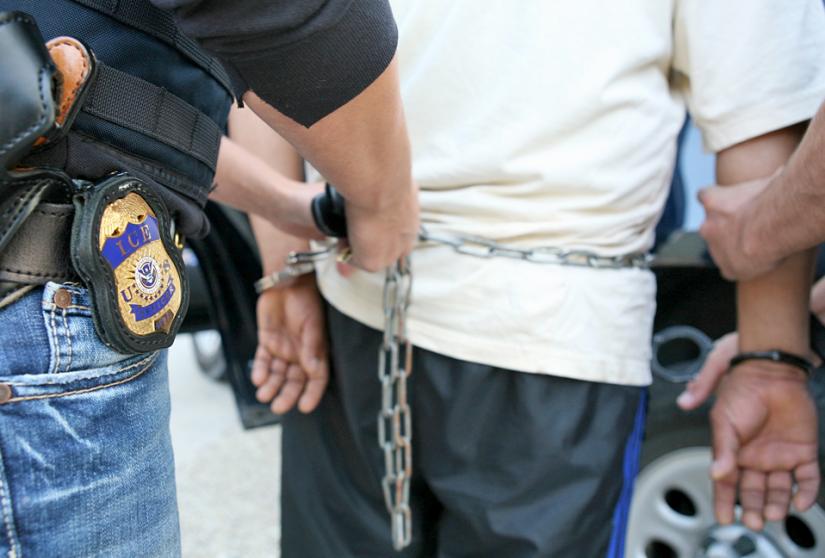 Immigration and Customs Enforcement agents prepare to transfer a detainee