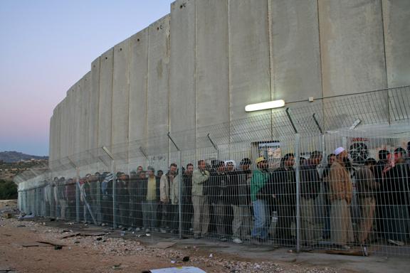 Palestinians wait in line before dawn to pass through a checkpoint outside Bethlehem