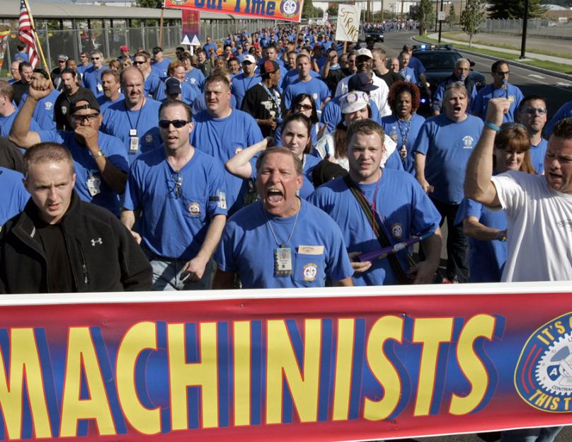 Boeing machinists march to their union hall to vote on the company's final contract offer