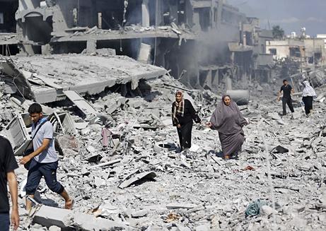 People walk through the rubble during a pause in the 2014 Israeli assault on Gaza