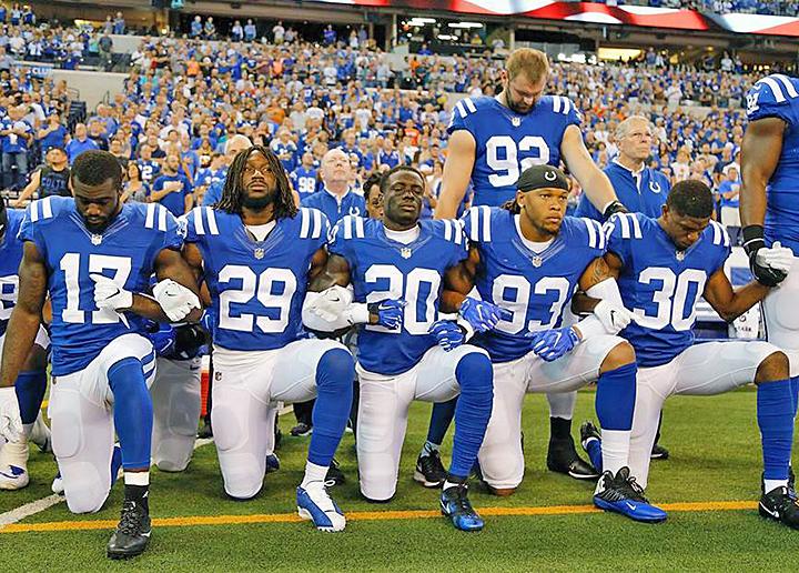 Members of the Dallas Cowboys take a knee during the national anthem