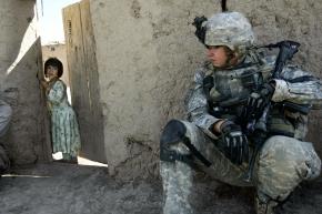 An Afghan girl looks on as U.S. troops carry out a mission