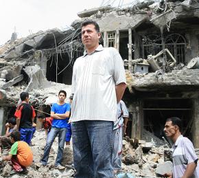 Iraqis in front of buildings demolished during U.S. attacks on Sadr City