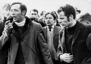 Civil rights organizer Eamonn Melaugh speaks at a housing rally in Derry as Eamonn McCann (right) looks on