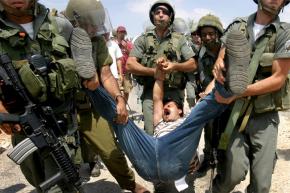 A Palestinian man is detained by Israel Defense Force soldiers