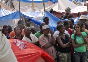 Displaced Haitians wait among makeshift tents for first aid supplies in Port-au-Prince