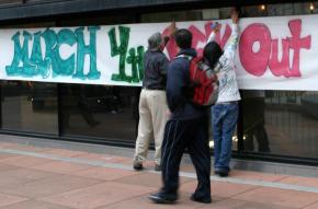 Activists post a banner for the March 4 Day of Action at Laney College in Oakland