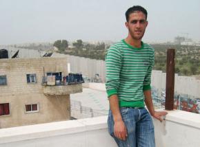 Bilal Jadou inside the Aida refugee camp, overlooking the separation wall and his home on the other side