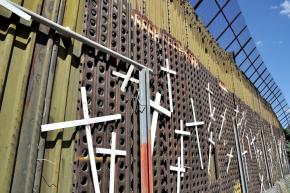 The U.S.-Mexico border wall, covered with crosses to commemorate those who died making the journey to the U.S.
