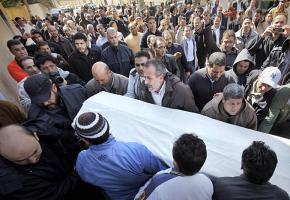 Mourners carry the body of a 44-year-old man killed in clashes with pro-Qaddafi forces in eastern Tripoli