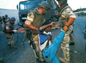 Italian troops drag away a Somali civilian wounded in U.S.-led bombing
