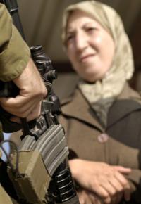 A Palestinian woman waits to pass through an Israeli checkpoint in the occupied West Bank