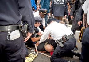Police force a protester to the ground in the midst of the Wall Street occupation