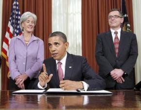 President Obama, flanked by Health and Human Services Secretary Kathleen Sebelius and cancer patient Jay Cuetara