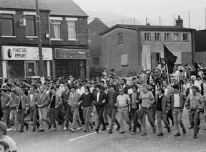 Demonstrators march with black flags to mourn the deaths of Irish hunger strikers in Long Kesh