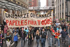 Protesters march through the rain in Chicago on May Day 2012