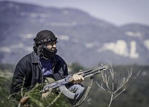 A Syrian rebel fighter holds a position during fighting near Idlib