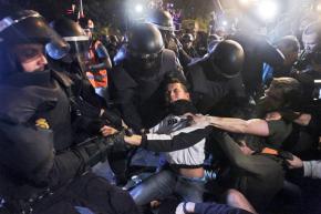 Spanish riot police attacking a protester in Madrid outside the parliament building