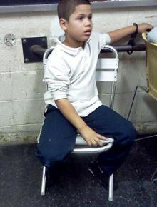 Seven-year-old Wilson Reyes' mother took this picture of him handcuffed inside a police station