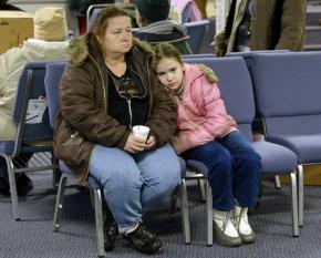 A mother and daughter wait for help at a government office