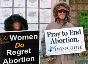 Anti-abortion protesters stand outside a women's health clinic