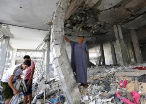 Gaza residents dig through the rubble of a building hit in an Israeli strike