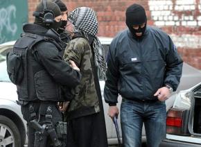 French police make an arrest during the spreading tide of raids