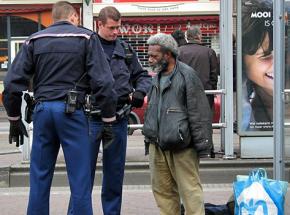 Two police officers harass a homeless man