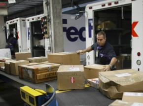 FedEx workers load packages at a shipping hub