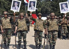 Syrian government troops pose with portraits of dictator Bashar al-Assad