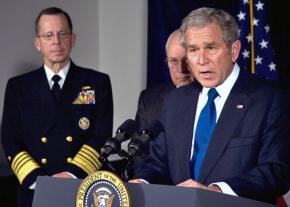 George W. Bush speaks at the Pentagon flanked by Dick Cheney and Joint Chiefs of Staff Chair Mike Mullen (left)