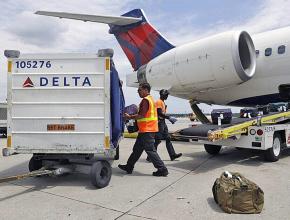 Baggage handlers load a passenger jet at Delta Air Lines