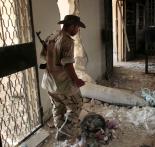 A Libyan rebel in Zawiyah guards an unexploded NATO bomb (Etienne De Malglaive | ABACA Press)