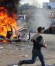 A car burns in the middle of the street as Libyans continue their mass protests against dictatorship