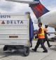 Baggage handlers load a passenger jet at Delta Air Lines