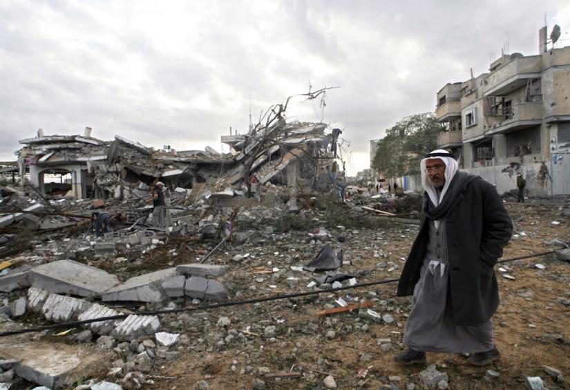 A Palestinian man walks past the rubble of a building destroyed in an Israeli air strike on Rafah in southern Gaza