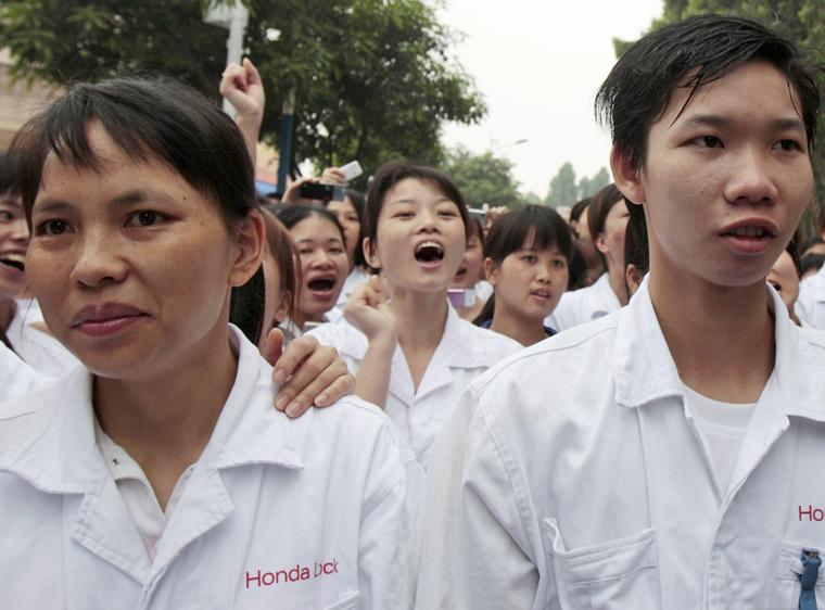 Strikers march outside the shut down Honda motor factory in Zhongshan, Guangdong province