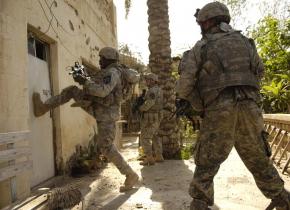U.S. soldiers kick in the door of a building in Buhriz, Iraq